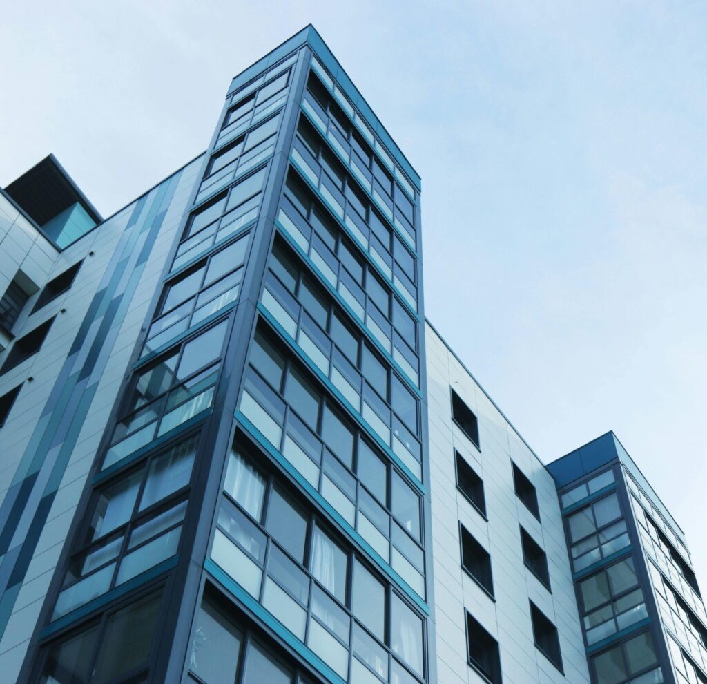 Low-angle view of a modern glass skyscraper against a clear sky in Poole, UK.